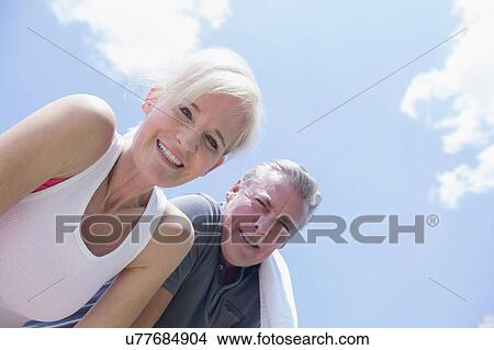 Picture - Portrait of smiling couple against sky. Fotosearch