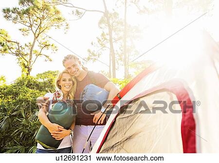 Portrait of smiling couple standing together next to tent View Large Photo Image Stock Image - Portrait of smiling couple standing together next to tent. Fotosearch