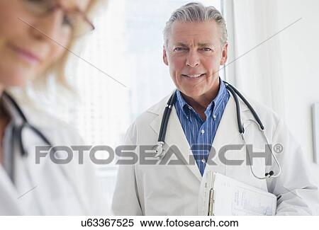 Stock Photography - Portrait of smiling male doctor with stethoscope. Fotosearch