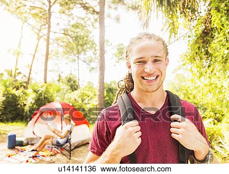 Stock Photograph - Portrait of smiling man and woman reading book. Fotosearch
