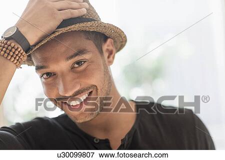 Stock Photo - Portrait of smiling man in straw hat. Fotosearch