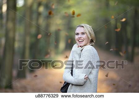Portrait of smiling woman while leaves falling View Large Photo Image Stock Photo - Portrait of smiling woman while leaves falling. Fotosearch