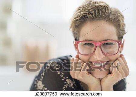 Stock Image - Portrait of smiling young woman wearing glasses. Fotosearch