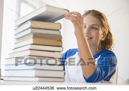 Portrait of teenage girl (12-13) stacking books View Large Photo Image Stock Photograph - Portrait of teenage girl (12-13) stacking books. Fotosearch