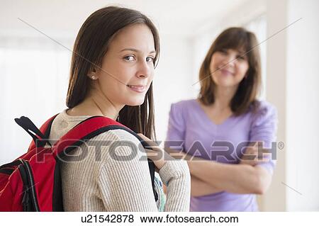 Stock Photo - Portrait of teenage student (14-15), mother in background. Fotosearch