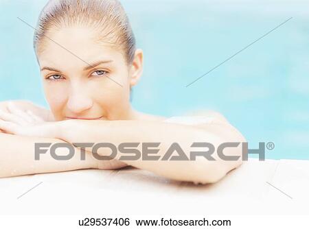 Stock Photograph - Portrait of woman on edge of swimming pool. Fotosearch