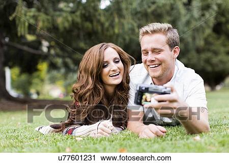 Portrait of young couple taking selfie in park View Large Photo Image Stock Image - Portrait of young couple taking selfie in park. Fotosearch