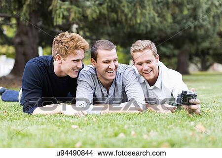 Portrait of young men taking selfie in park View Large Photo Image Picture - Portrait of young men taking selfie in park. Fotosearch