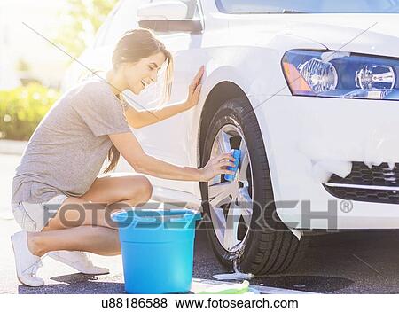 Portrait of young woman washing white car View Large Photo Image Stock Photo - Portrait of young woman washing white car. Fotosearch