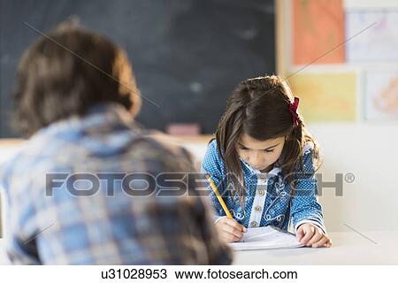 Stock Image - Pupils (6-7) learning in classroom. Fotosearch