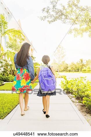 Rear view of girl (6-7) holding hands with her mom outdoors View Large Photo Image Stock Image - Rear view of girl (6-7) holding hands with her mom outdoors. Fotosearch