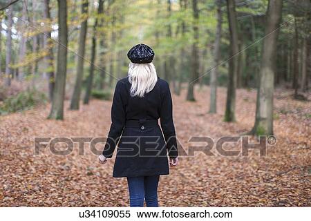 Stock Photography - Rear view of woman in autumn forest. Fotosearch