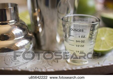 Stock Image - Shot glass and cocktail shaker on tray. Fotosearch