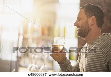 Side view of man having drink in bar View Large Photo Image Stock Photo - Side view of man having drink in bar. Fotosearch