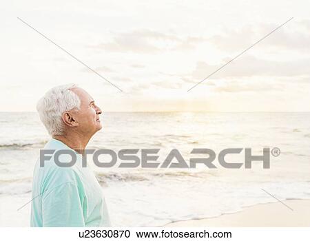 Side view of senior man smiling on beach View Large Photo Image Stock Image - Side view of senior man smiling on beach. Fotosearch