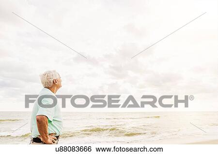 Side view of senior man standing on beach View Large Photo Image Stock Photograph - Side view of senior man standing on beach. Fotosearch