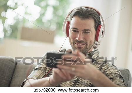 Smiling man listening to music View Large Photo Image Stock Image - Smiling man listening to music . Fotosearch