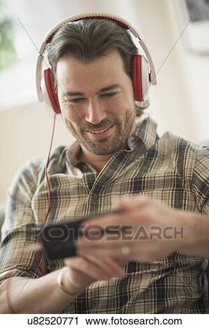 Smiling man listening to music View Large Photo Image Stock Image - Smiling man listening to music . Fotosearch