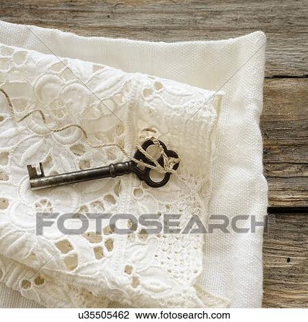 Stock Image - Studio shot of antique key on lace cloth. Fotosearch