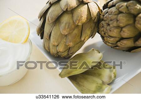 Stock Photograph - Studio shot of artichokes and dip. Fotosearch