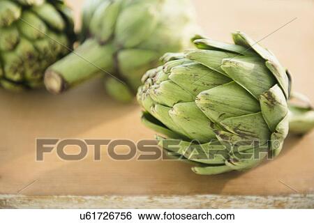 Studio shot of artichokes on table View Large Photo Image Stock Photograph - Studio shot of artichokes on table. Fotosearch