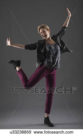 Studio shot of cheerful woman with arms raised View Large Photo Image Stock Photo - Studio shot of cheerful woman with arms raised. Fotosearch