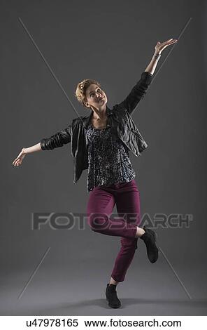 Stock Photography - Studio shot of cheerful woman with arms raised. Fotosearch