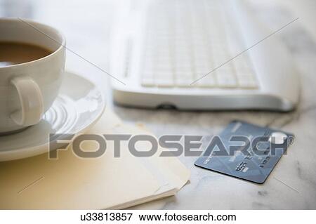 Stock Photo - Studio shot of coffee cup, computer keyboard, files and credit card. Fotosearch