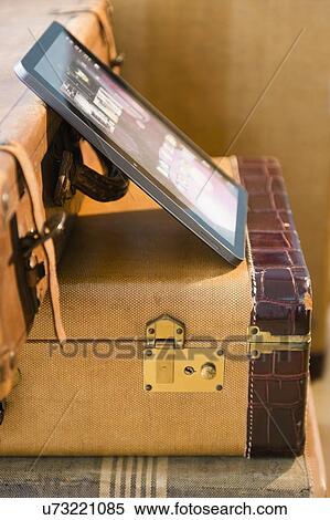 Stock Photography - Studio shot of digital tablet on suitcases. Fotosearch