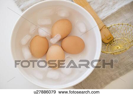 Stock Photo - Studio shot of eggs in water with ice. Fotosearch