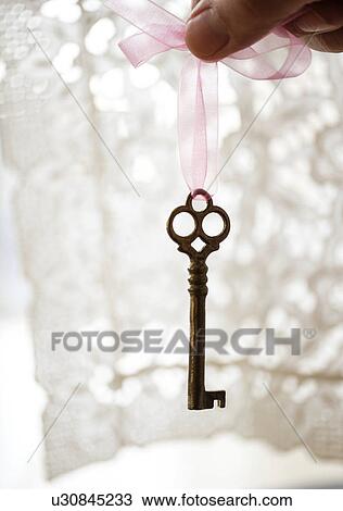 Studio shot of hand holding antique key View Large Photo Image Stock Image - Studio shot of hand holding antique key. Fotosearch