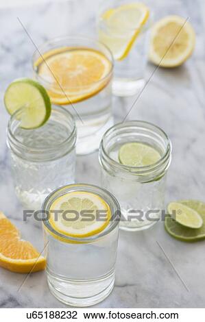 Stock Image - Studio shot of lemon, orange and lime drinks. Fotosearch