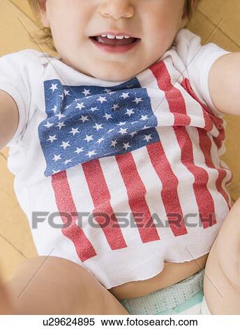 Stock Photography - Studio shot of little girl (18-23 months) in t-shirt with American flag. Fotosearch