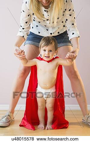 Studio shot of mother holding baby daughter (18-23 months) in costume View Large Photo Image Stock Photo - Studio shot of mother holding baby daughter (18-23 months) in costume. Fotosearch