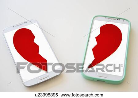 Stock Photography - Studio shot of smart phones with broken heart on screen. Fotosearch