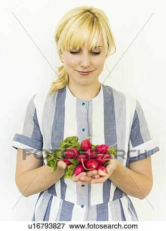 Studio shot of woman holding bunch of fresh radishes View Large Photo Image Stock Photo - Studio shot of woman holding bunch of fresh radishes. Fotosearch