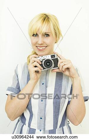 Studio shot of woman holding camera View Large Photo Image Picture - Studio shot of woman holding camera. Fotosearch