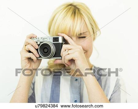 Studio shot of woman holding camera View Large Photo Image Picture - Studio shot of woman holding camera. Fotosearch