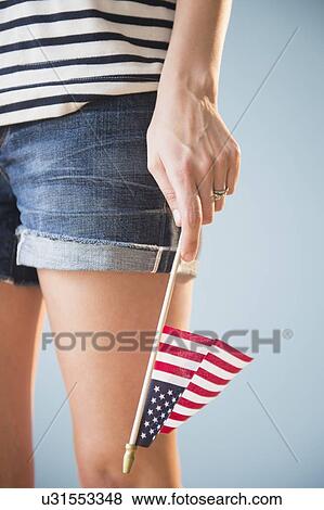 Stock Photo - Studio shot of woman's hand holding American flag. Fotosearch