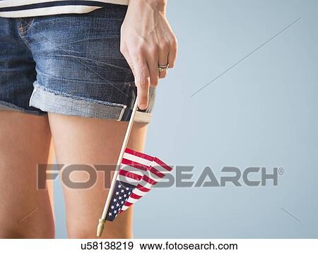 Stock Photo - Studio shot of woman's hand holding American flag. Fotosearch