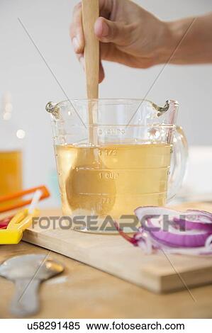 Stock Photography - Studio shot of woman's hand stirring liquid in jug. Fotosearch