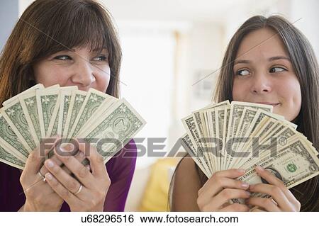 Teenage girl (14-15) and her mom holding dollar bills View Large Photo Image Stock Photograph - Teenage girl (14-15) and her mom holding dollar bills. Fotosearch