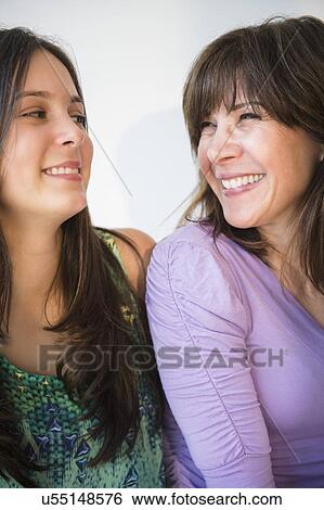 Stock Photograph - Teenage girl (14-15) and mom laughing. Fotosearch