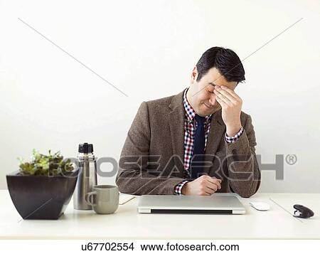 Picture - Tired man sitting in office. Fotosearch