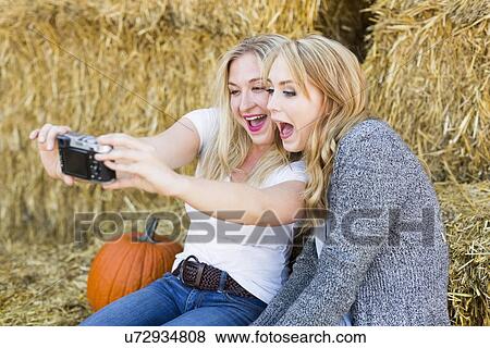 Stock Photo - Two friends taking selfie in field. Fotosearch