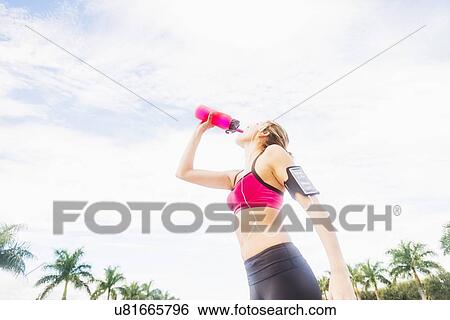 Woman drinking water from bottle View Large Photo Image Stock Photograph - Woman drinking water from bottle. Fotosearch