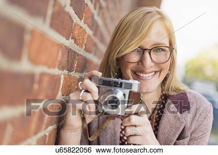 Stock Photograph - Woman holding vintage camera . Fotosearch