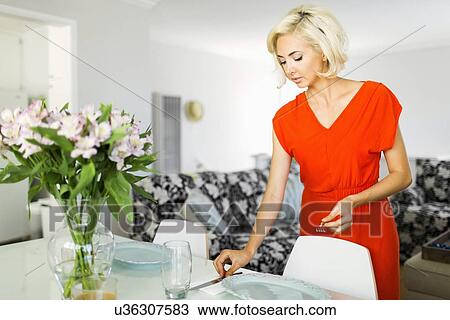 Woman in red dress setting the table View Large Photo Image Stock Image - Woman in red dress setting the table. Fotosearch