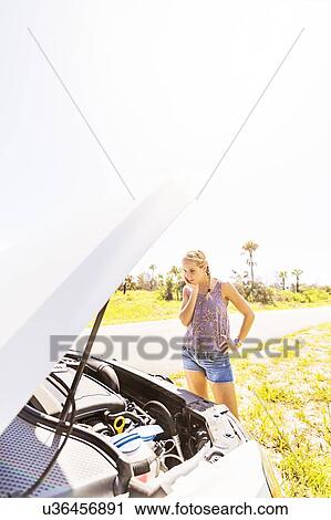 Woman looking at car engine View Large Photo Image Stock Image - Woman looking at car engine. Fotosearch