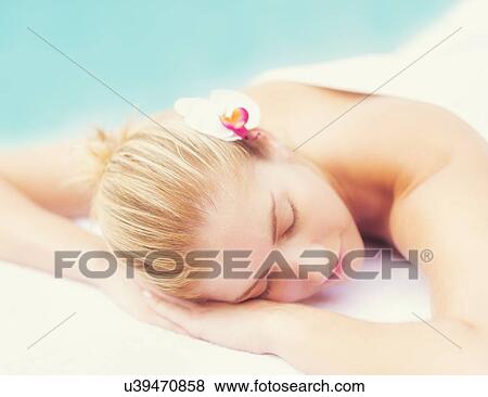 Stock Photo - Woman lying next to swimming pool. Fotosearch